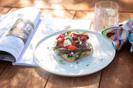 Steak sandwich on plate with magazine