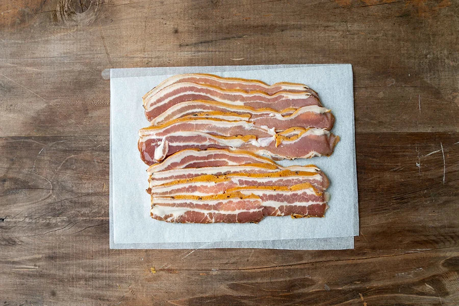 uncooked streaky bacon on baking paper