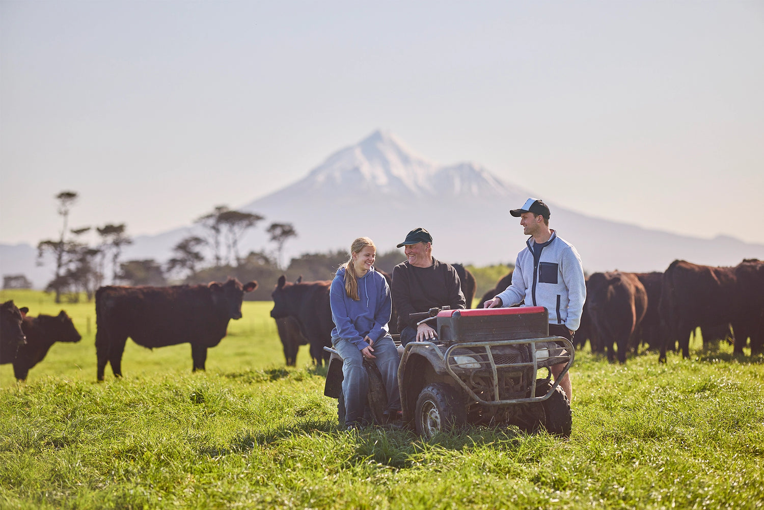 Three generations of family on a farm bike with steer
