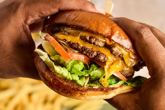 hands holding double patty cheeseburger