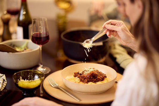 sprinkling cheese on pasta dish