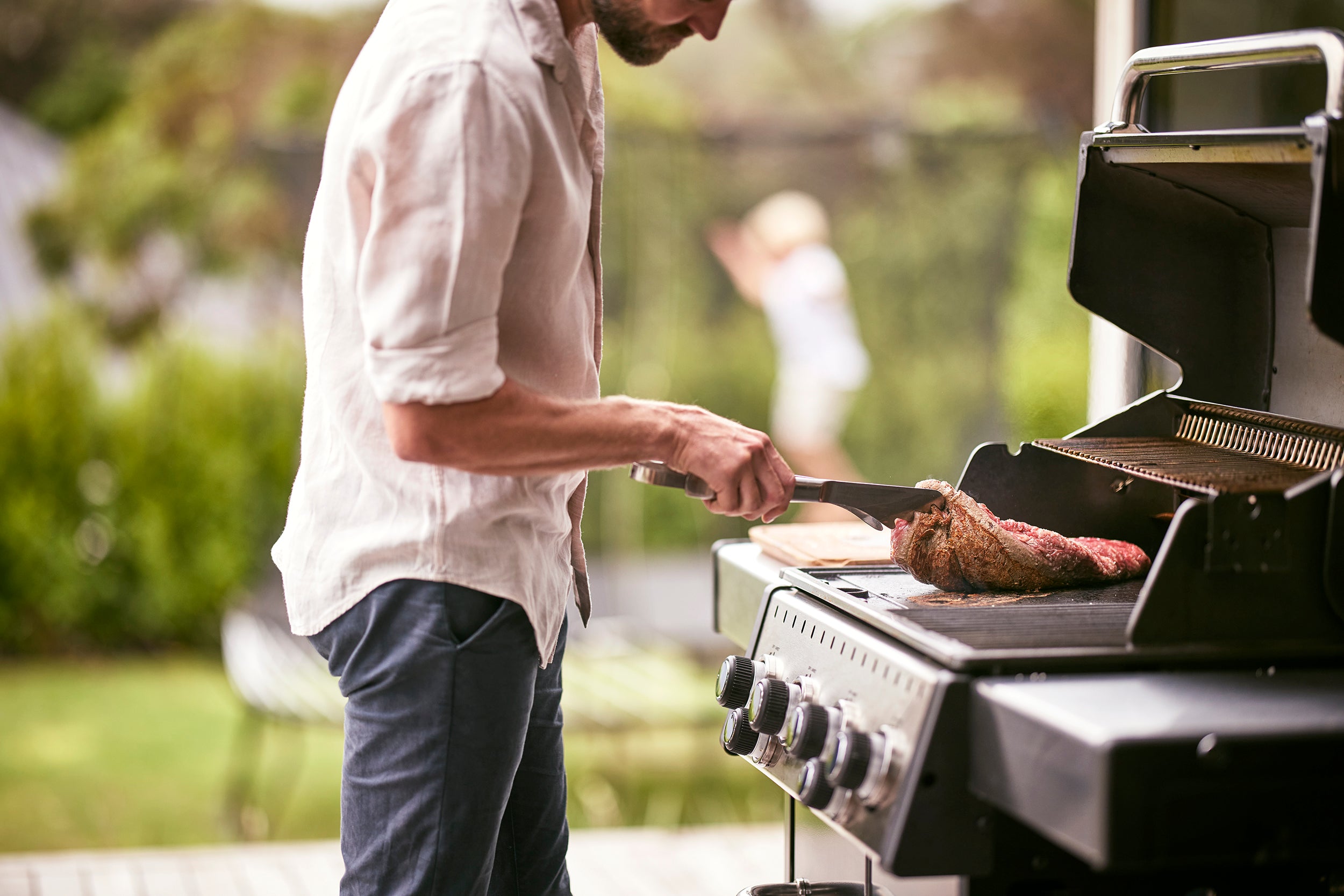 Male cooking beef fillet on BBQ